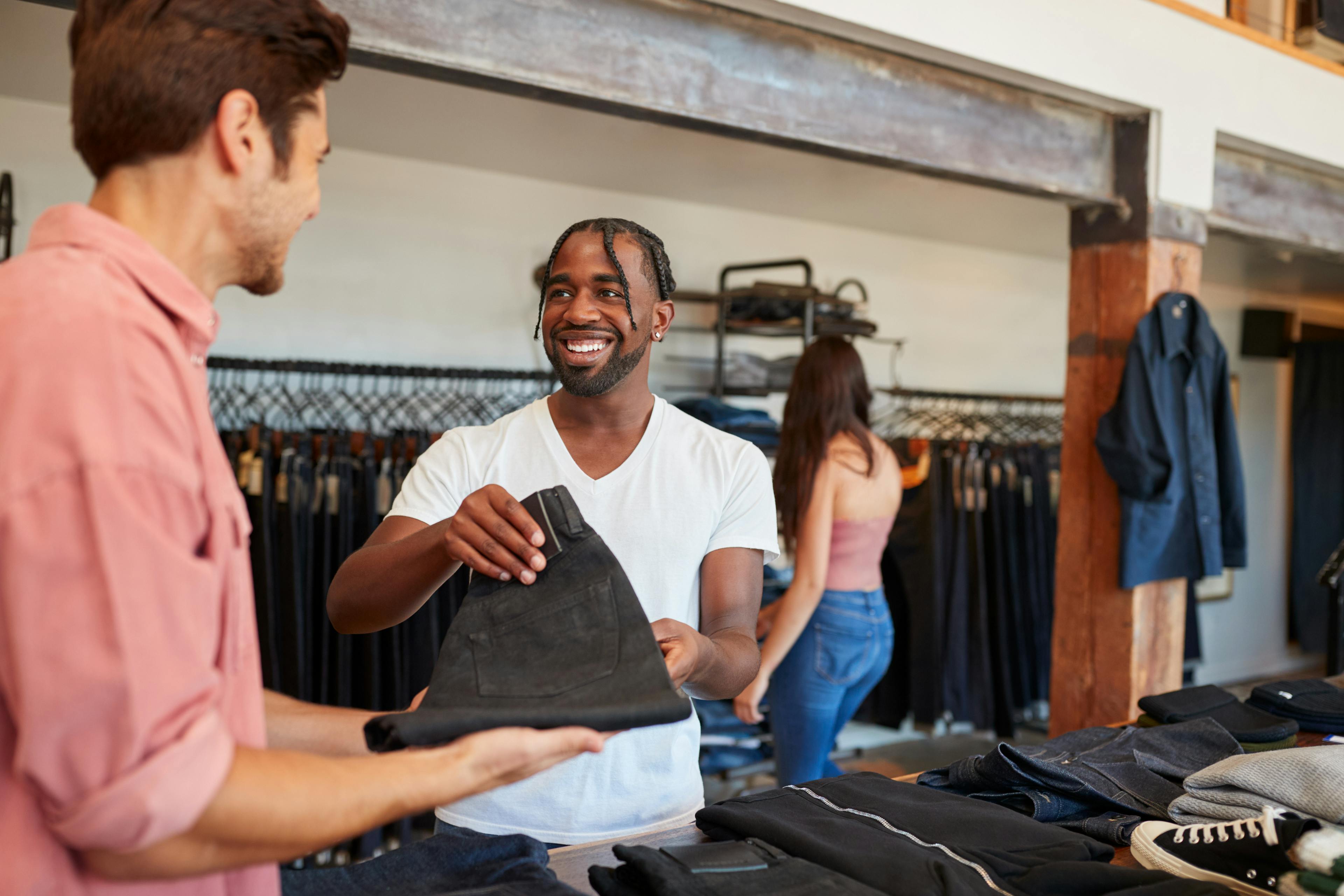 friendly male store associate assisting male shopper in apparel store